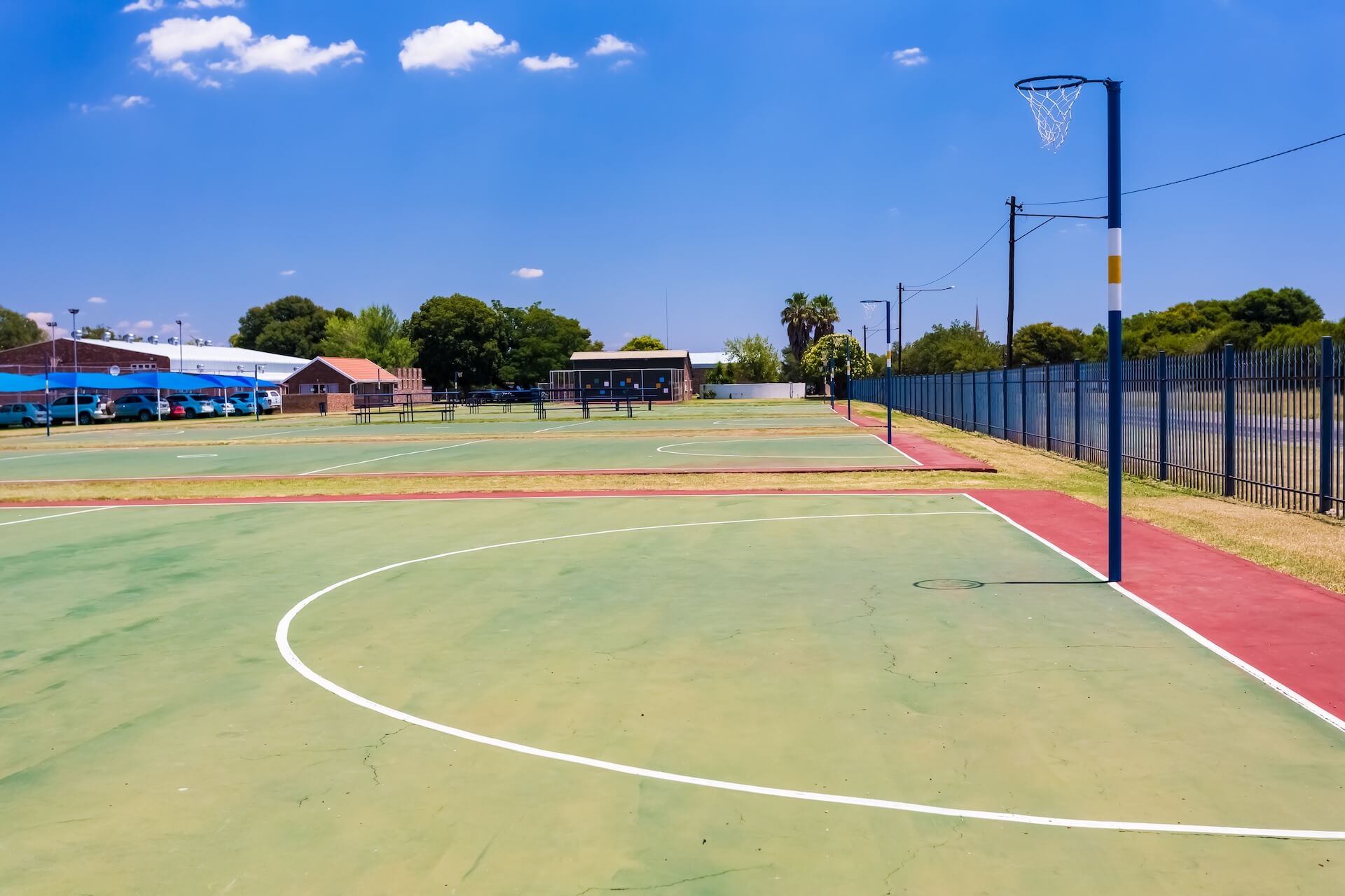 Several netball courts on a school's campus | Featured image for the Netball Court Cleaning page from MKL Pressure Cleaning.